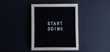 Black letter board with the motivational phrase 'Start Doing' in white text on a gray background.