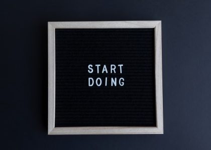 Black letter board with the motivational phrase 'Start Doing' in white text on a gray background.